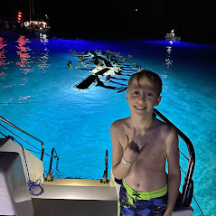 Young boy doing shaka in front of raft