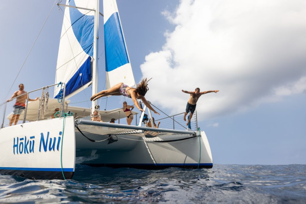 Girl and boy diving off Hoku Nui boat